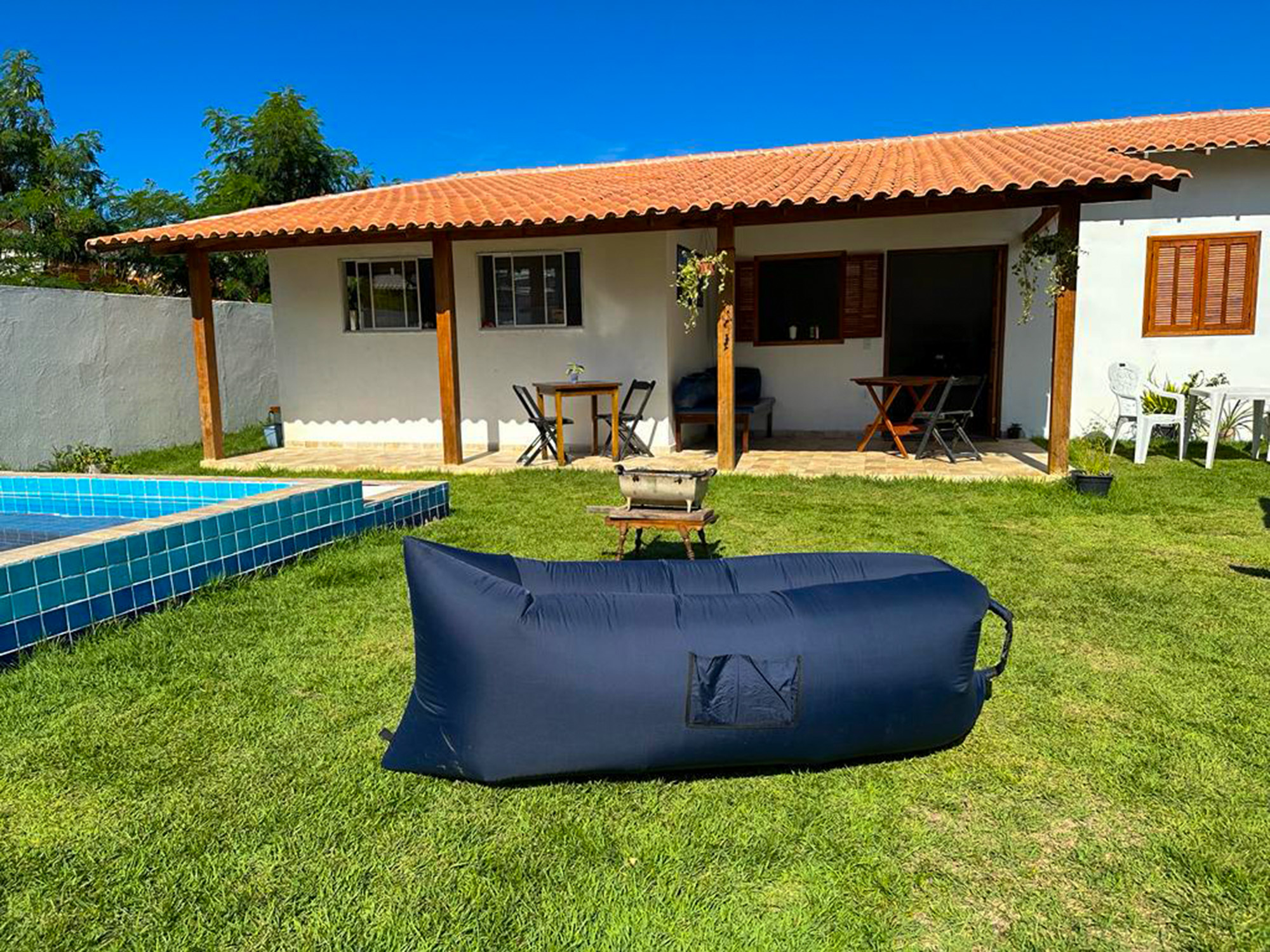 Jardim e varanda com mesas junto à piscina