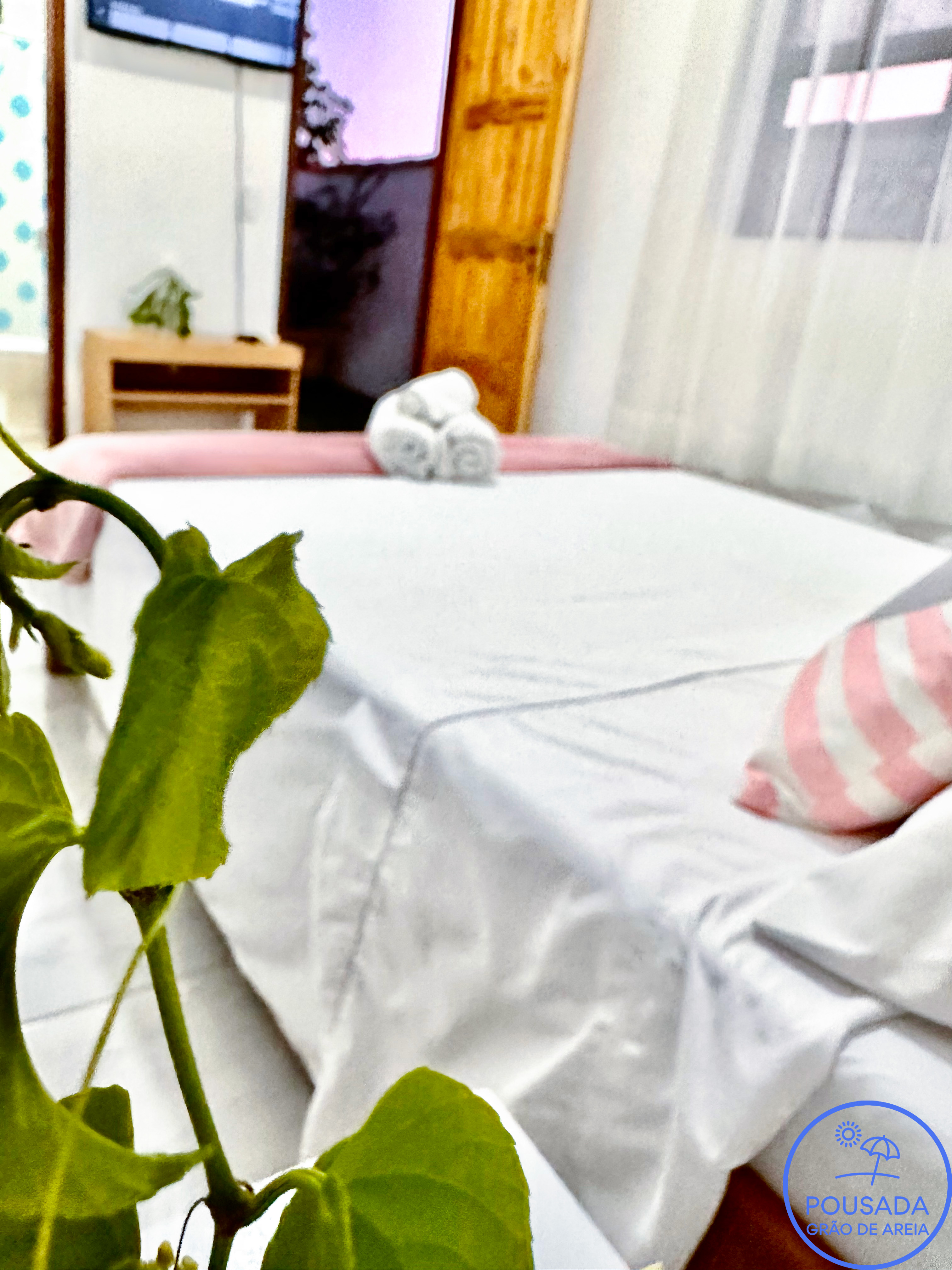 Detalhes da cama de casal e das toalhas na suíte